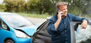 Mature Male Motorist Involved in Car Accident Calling Insurance