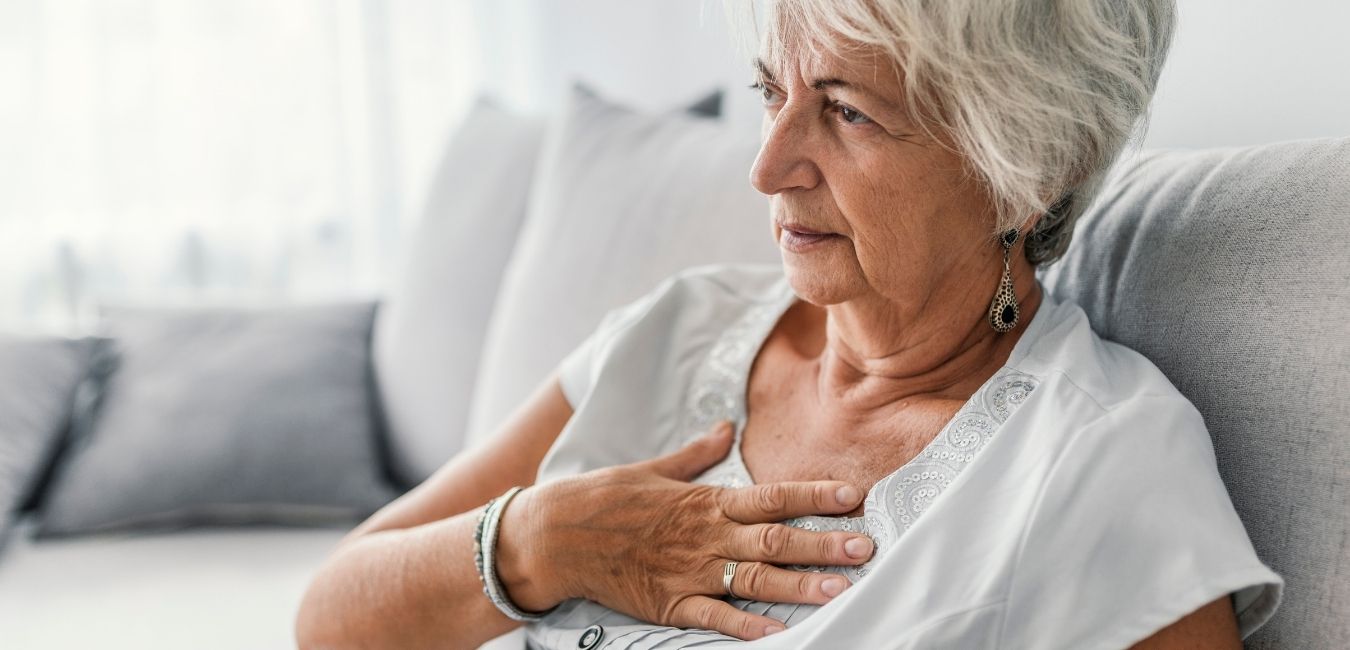 Senior woman suffering from heartburn or chest discomfort symptoms